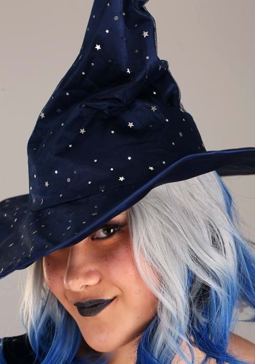Picture of a caucasion womans face wearing a dark blue sparkly witches hat over top of chin length white hair with blue ends