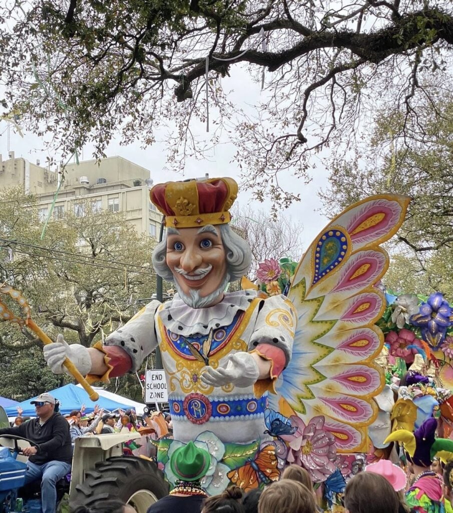 Mardi Gras parade floats in New Orleans with crowds, throws, and colorful Carnival energy.