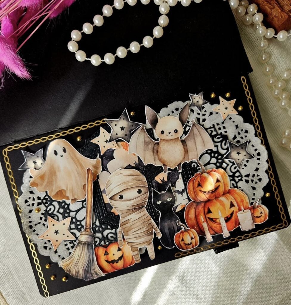Cute Halloween scrapbook layout featuring a ghost, bat, mummy, black cat, and pumpkins with candles on a black background