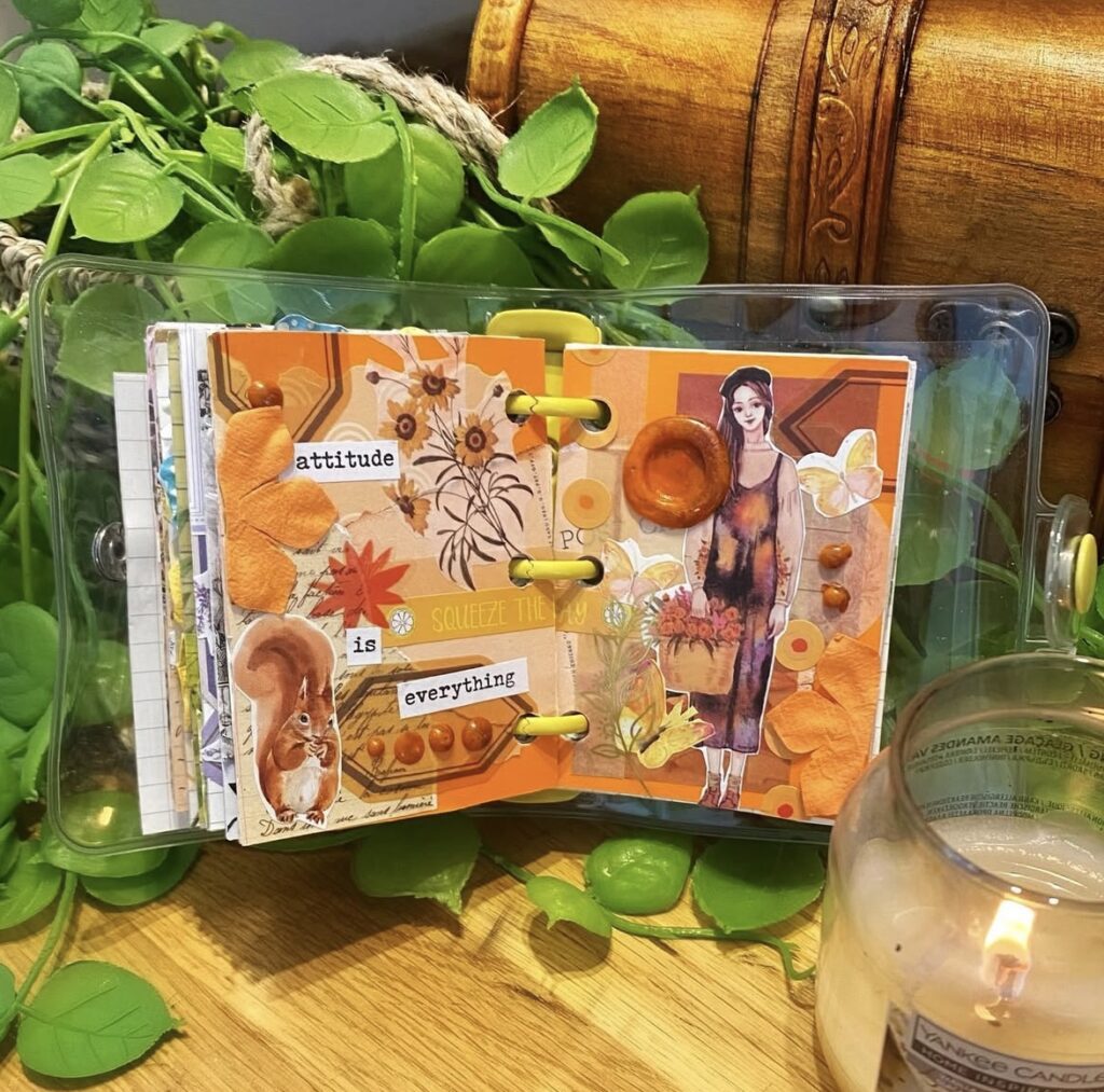 Aesthetic orange scrapbook layout with botanical stickers, stamps, and soft vintage vibes. Credit: myweejournal on Instagram.