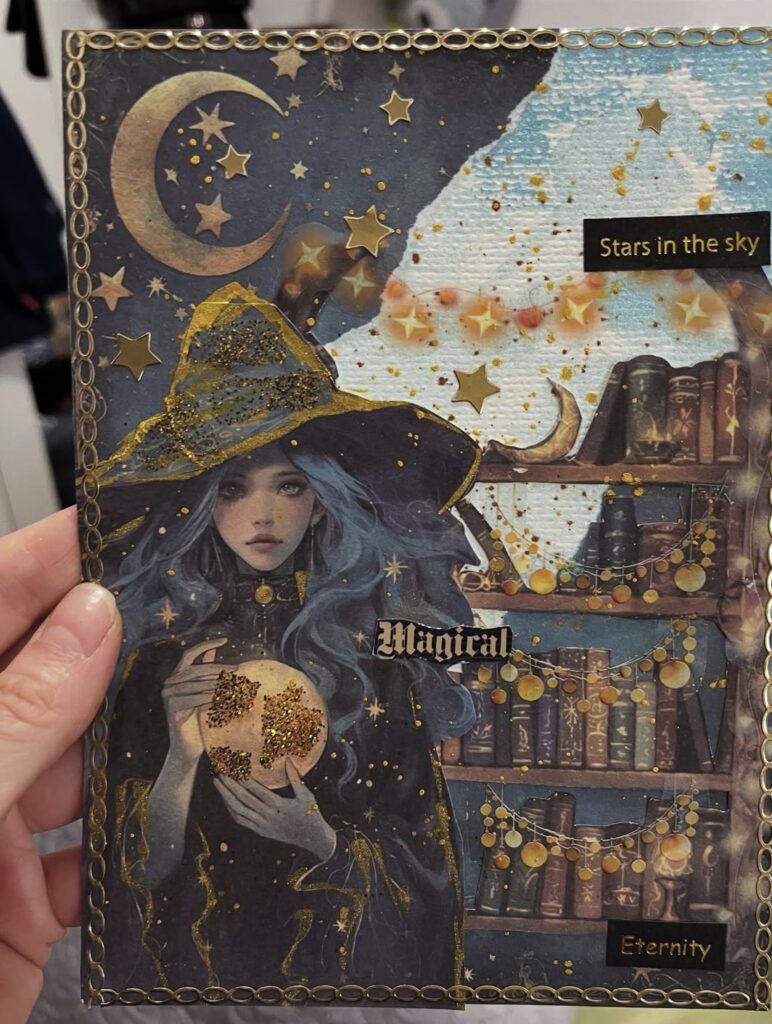 Dreamy journal card with a blue-haired witch, glowing orb, gold stars, moon, and a magical bookcase for an enchanting witchy scene. Credit: @firstjournalbyalexandra