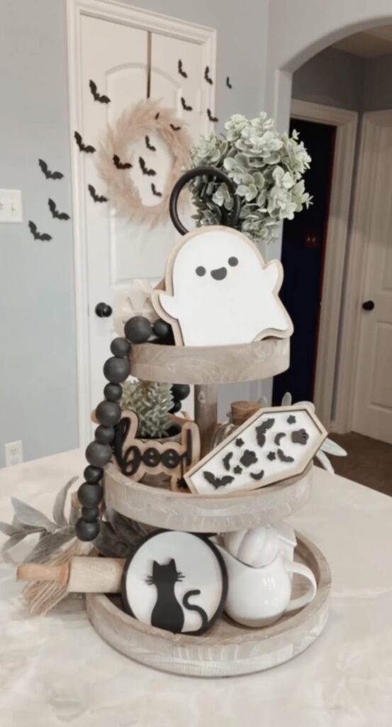 Ghost-shaped cookies on a farmhouse tiered tray with tan and black accents, ready for a Halloween party treat display. Credit: av_home_design.