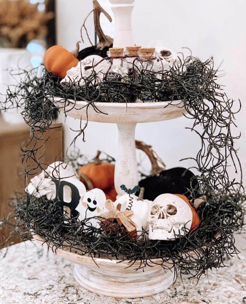 Skeleton-themed tiered tray decorated with spanish moss and skulls. Get skeleton tray ideas at www.slowestuff.com.