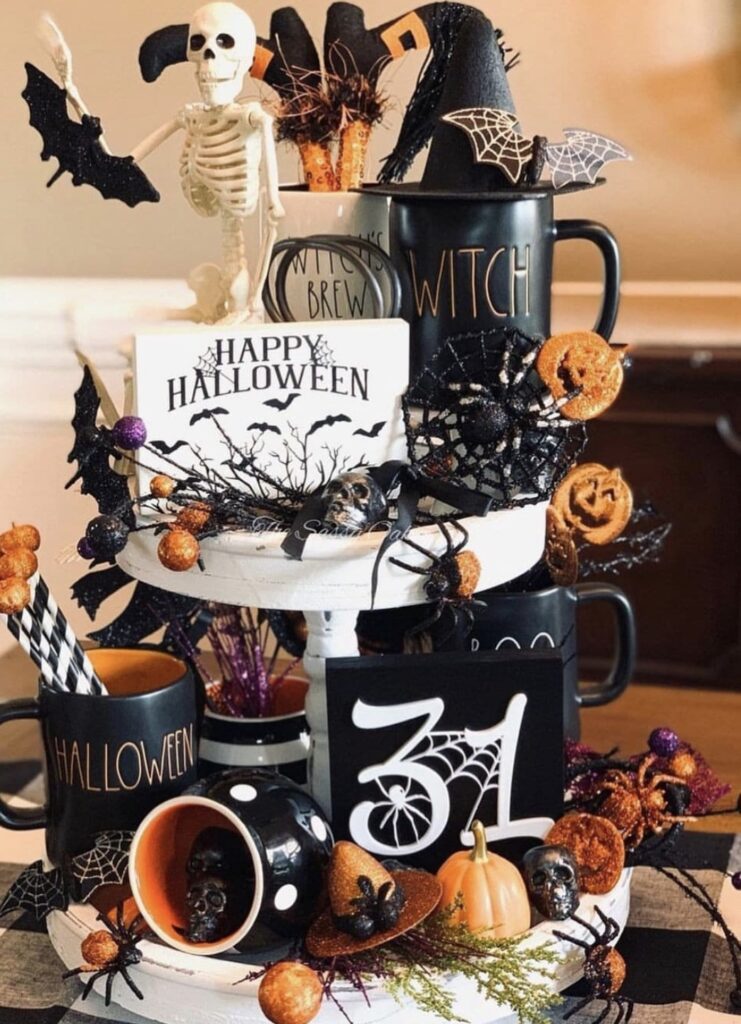 Skeleton tiered tray decorated for Halloween in black, white and orange with skeleton, bats, spooky mini figurines, and Halloween signs. Inspo for skeleton tray decor ideas at www.slowestuff.com.