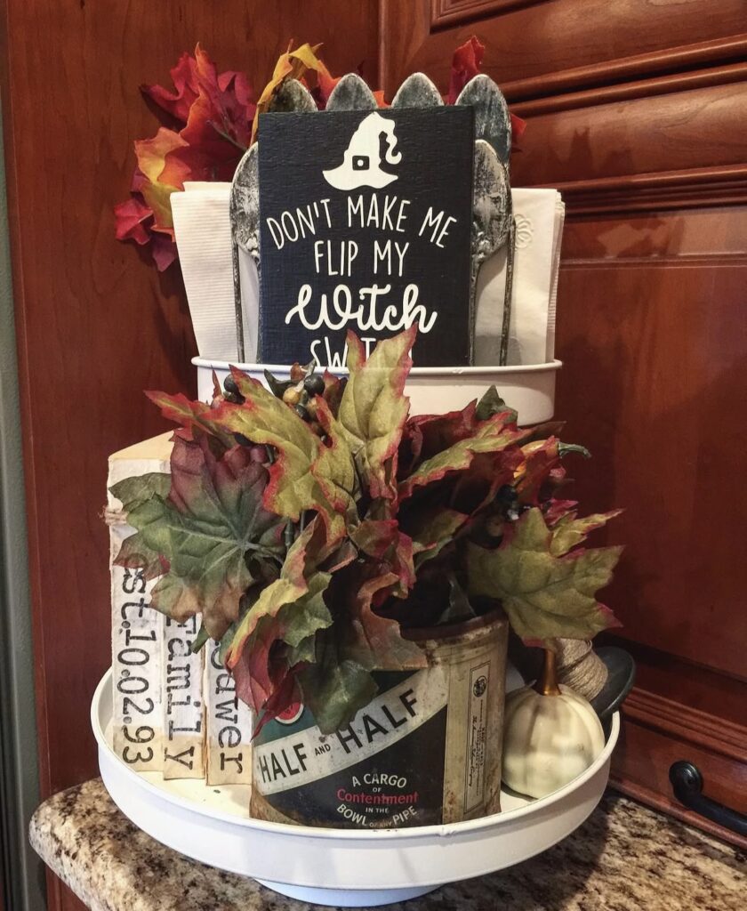 Magical witch tiered tray styled with a vintage witch figurine, old-timey potion bottles, and rustic Halloween decor. Credit: erin_b_thankful, www.slowestuff.com