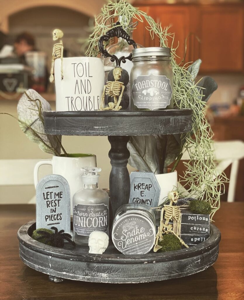 Halloween tiered tray styled with mini skeletons, tombstones and seasonal mugs. See more skeleton tray decor ideas at www.slowestuff.com.