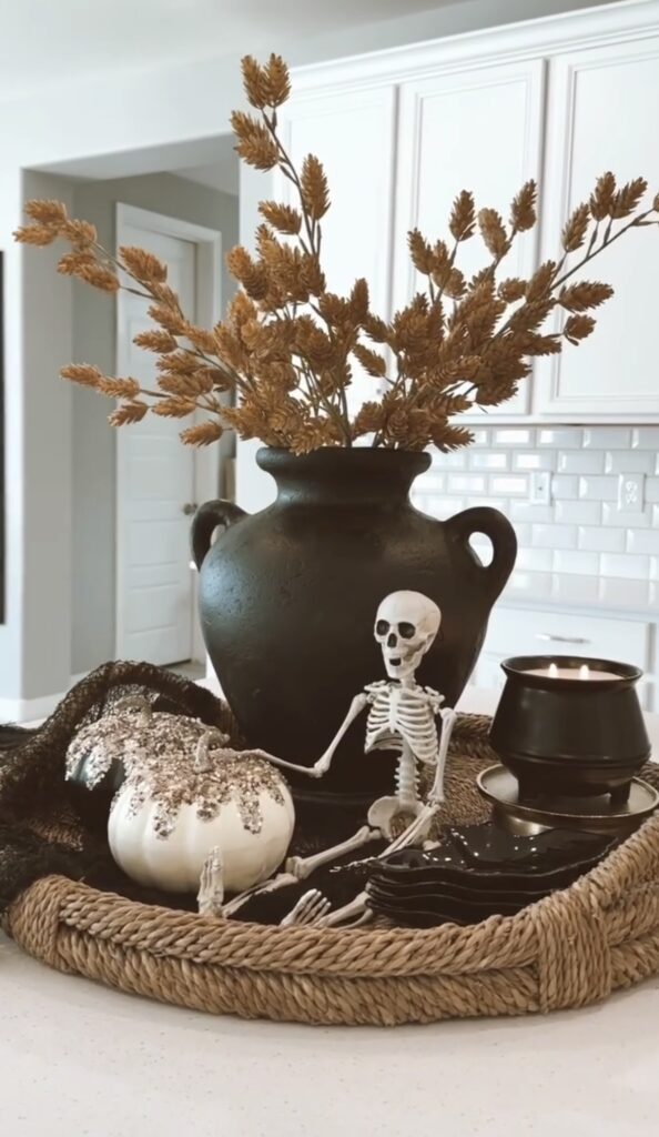 Cute and elegant Halloween tray with skeleton, black vase with fall foliage, candle, and pumpkin. Find skeleton tray inspiration at www.slowestuff.com.