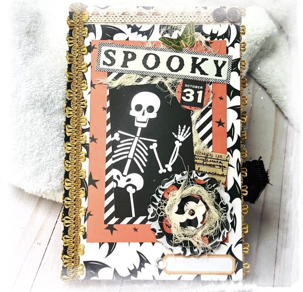 Spooky skeleton scrapbook cover, orange and black Halloween theme. Credit: artisan_b_boutique