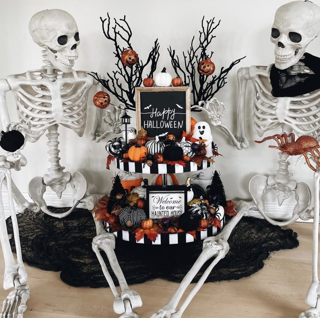 Skeleton tray decorated with creepy-cute details, skull accents, spooky signs, and bone props for Halloween. Skeleton tiered tray ideas at www.slowestuff.com.