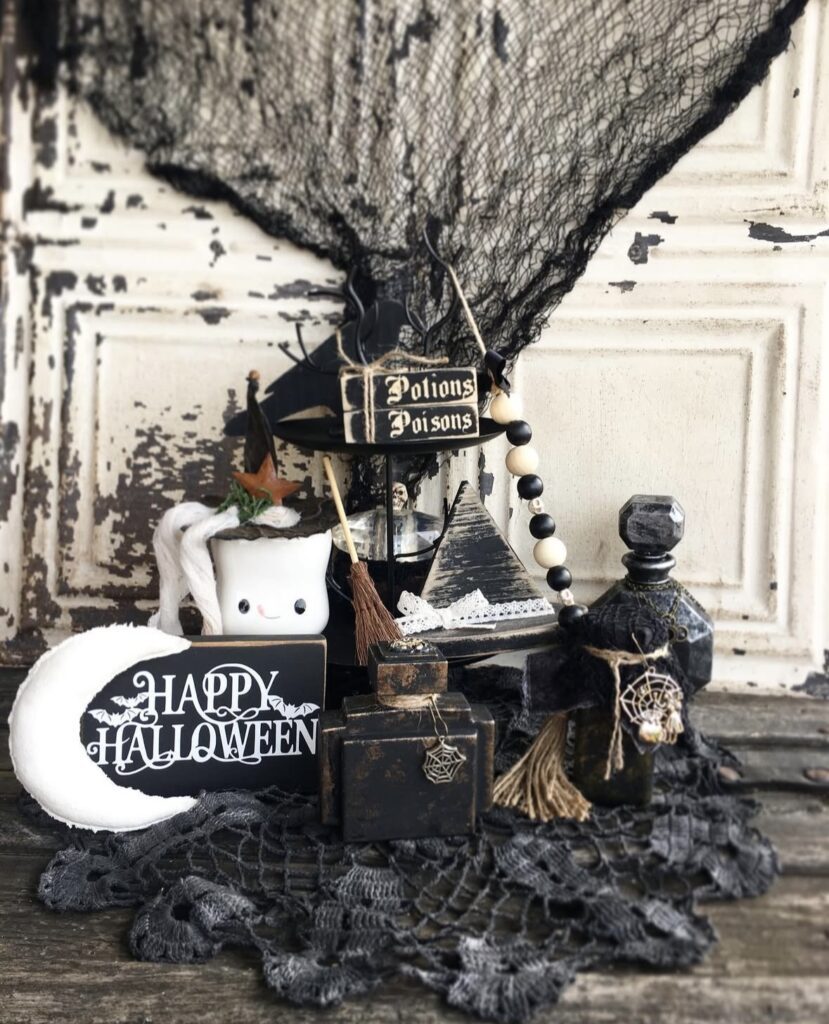 Mystical witch inspired Halloween tiered tray with half moon sign, potion bottles, and moody purple styling. Credit: primwichhollow, www.slowestuff.com