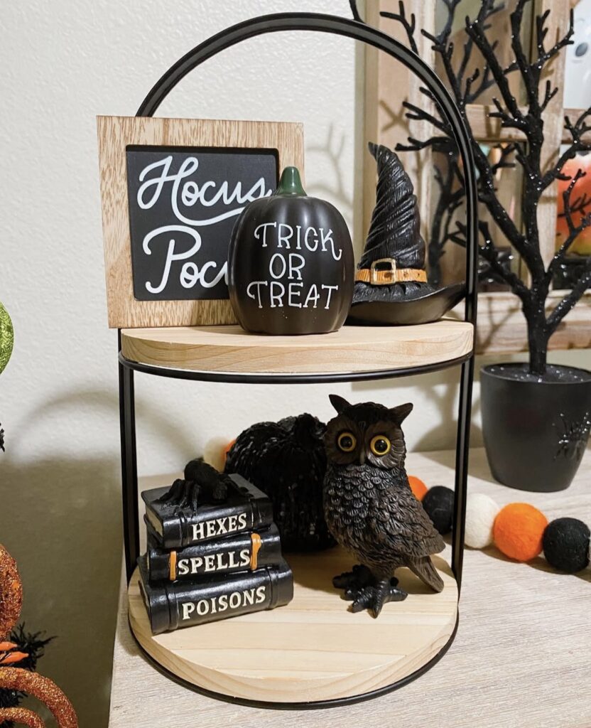 Halloween witch themed tiered tray featuring owl figurine, spell book, and black and purple accents. Credit: nancy_loves2shop, www.slowestuff.com