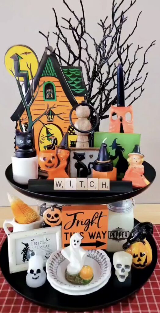 Witchcore Halloween tiered tray with scrabble tiles spelling “witch,” cauldron, spell books, and witchy knick knacks. Credit: amjordan99, www.slowestuff.com
