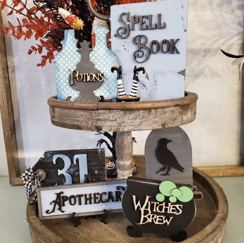 Witchcore Halloween tiered tray with spell book, apothecary sign, and raven figurine. Credit: graceandrays, www.slowestuff.com