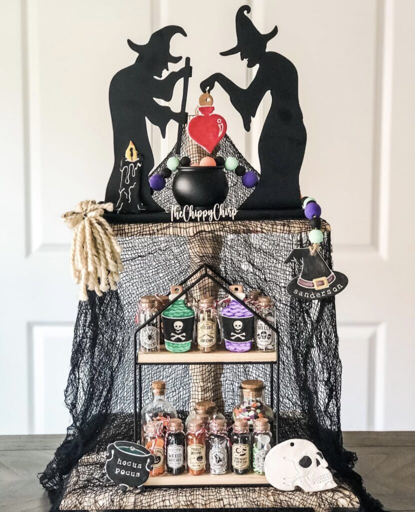 Witch silhouette Halloween tray with black mesh, apothecary bottles, and double witch cutouts. Credit: thestampedcottage, www.slowestuff.com