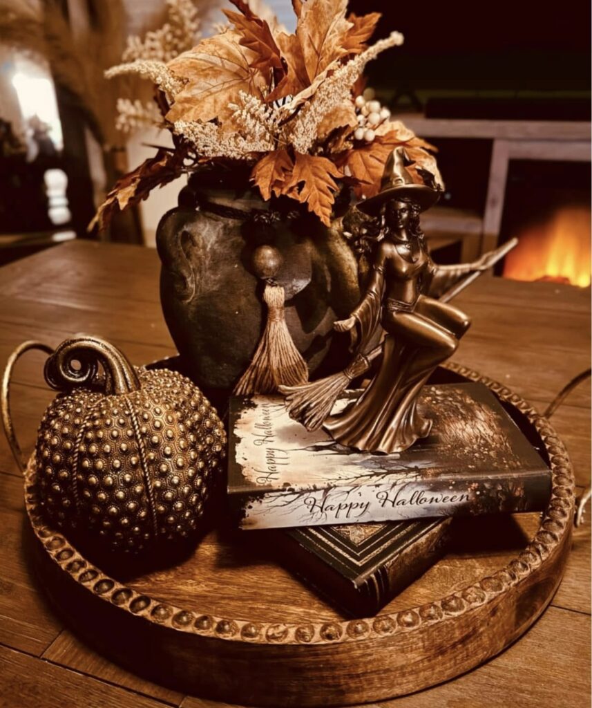 Elegant golden Halloween tray with a bronze witch figurine, broom, and subtle autumn accents. Credit: Stella Marie Caiozzo, www.slowestuff.com
