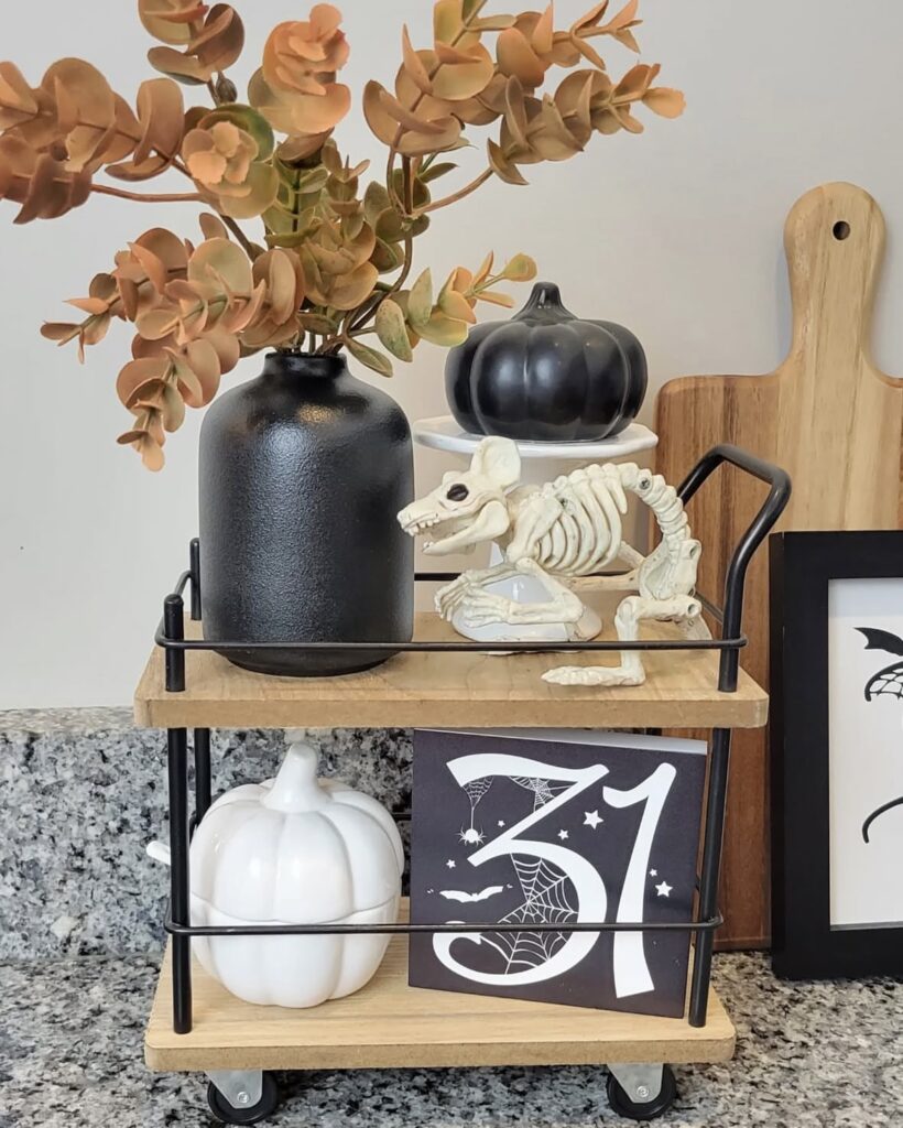 Tiered tray decorated for Halloween with animal skeleton plus pumpkin, 31 sign, and fall foliage and Halloween-themed signs. More skeleton tray ideas at www.slowestuff.com.