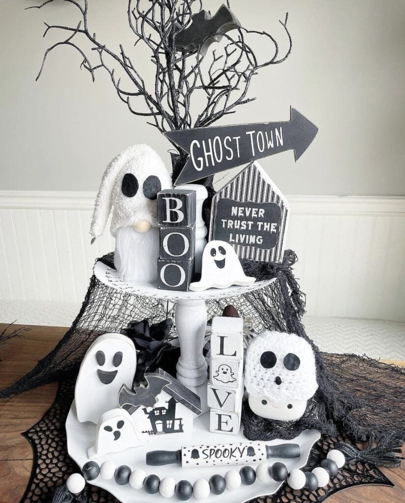 Black and white themed ghost tiered tray with ghost mugs, little pumpkins, and a rustic wood base—super cute and classic. Credit: kraftykrissycrochet.