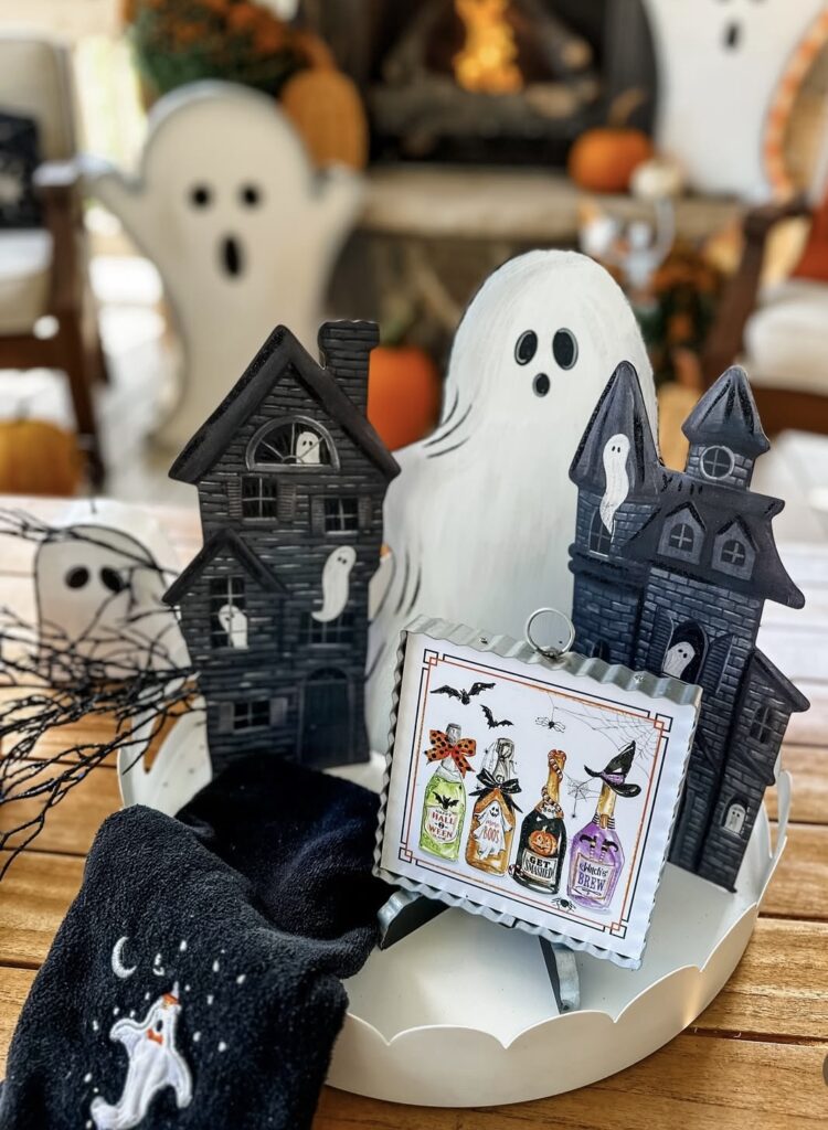Halloween tray decorated with cloth ghosts and metal haunted houses, accented with soft neutrals for an elevated, modern Halloween look. Credit: fidlinaroundhome.