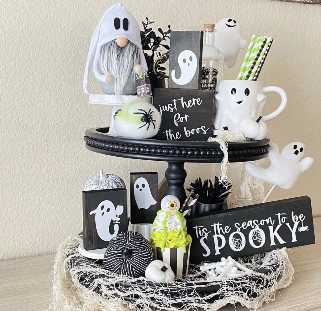 Black tray with neon green accents, ghost figurines, and “Just Here For The Boos” sign—fun and funky Halloween style! Credit: allthedayscreations.