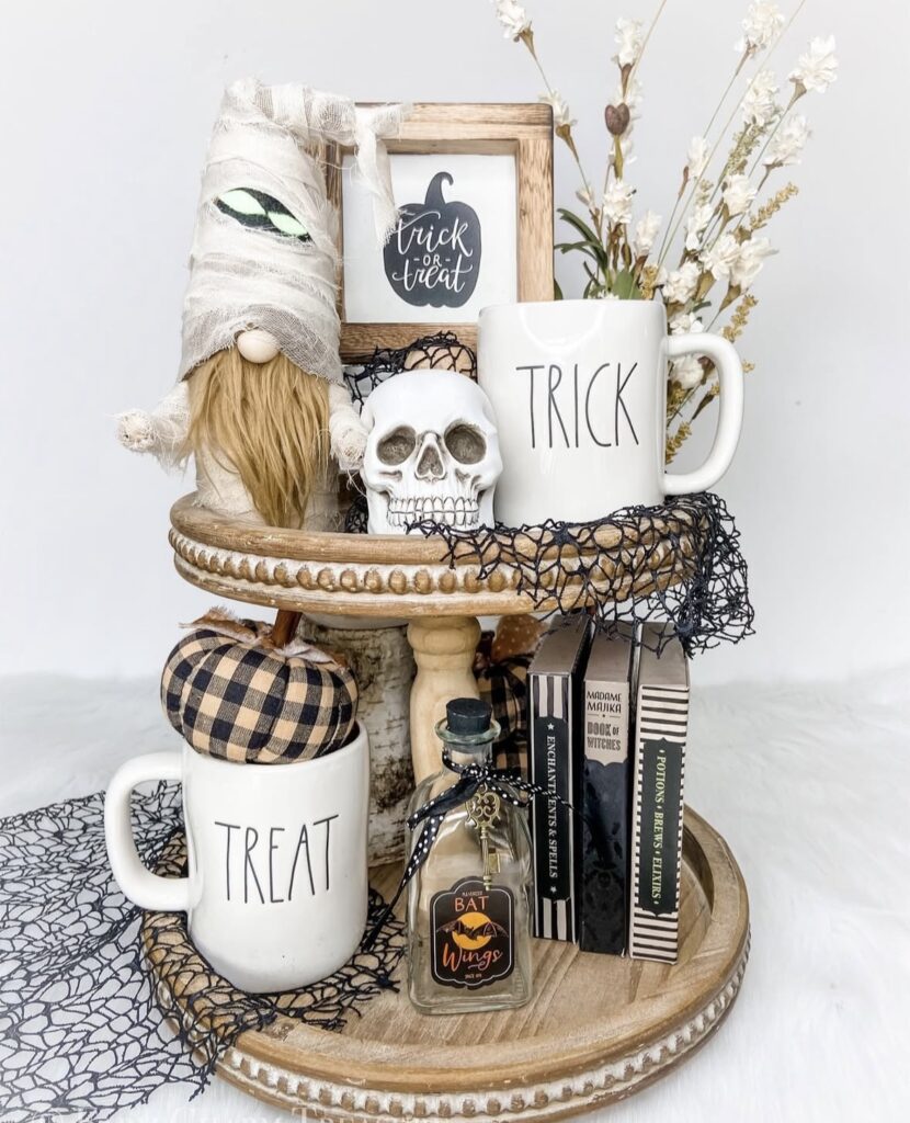 Beautiful Halloween skeleton tray decorated in neutral shades with skull, white mugs, halloween themed books and foliage for a spooky centerpiece. See more at www.slowestuff.com.