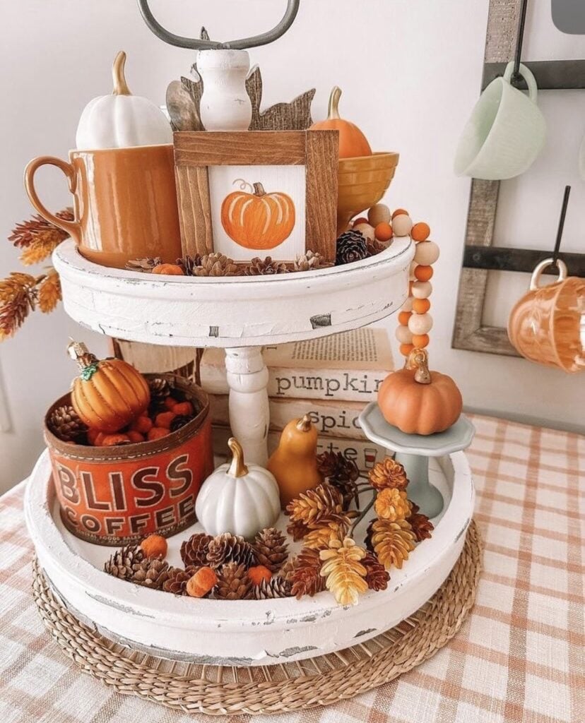 Halloween coffee bar setup with a white tiered tray featuring ghost mugs, themed mini signs, and candy corn