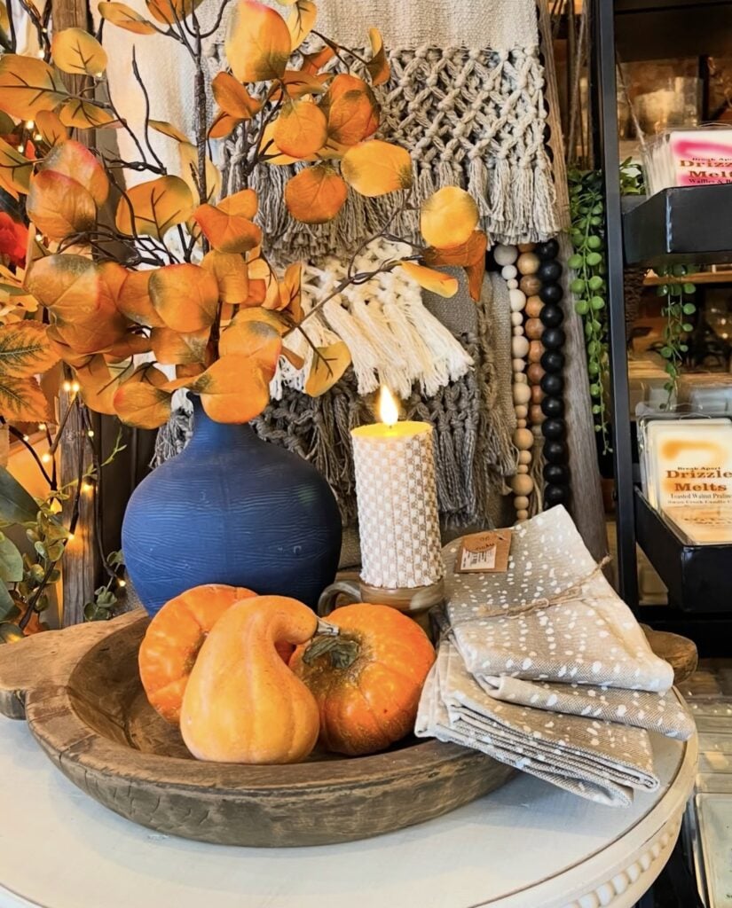Blue vase with orange leaves and pumpkins on fall centerpiece tray