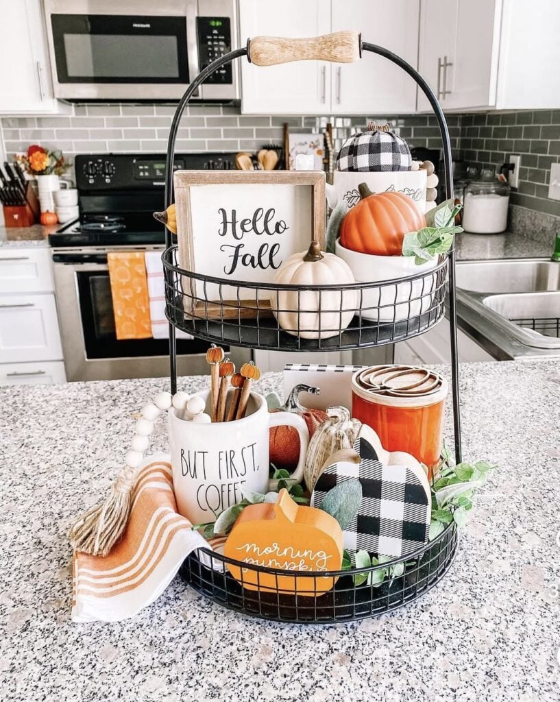 Black-and-white Halloween tiered tray with ghost mugs, wooden bead garlands, and mini orange pumpkins