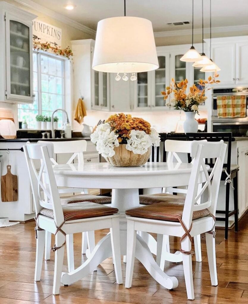 Neutral kitchen dining corner with copper accents and a fall flowers centerpiece.
