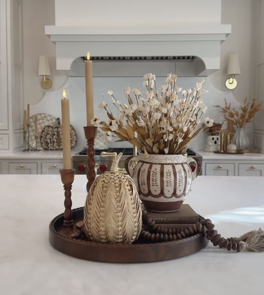 Dark tray with striped vase, wicker pumpkin, and candlesticks