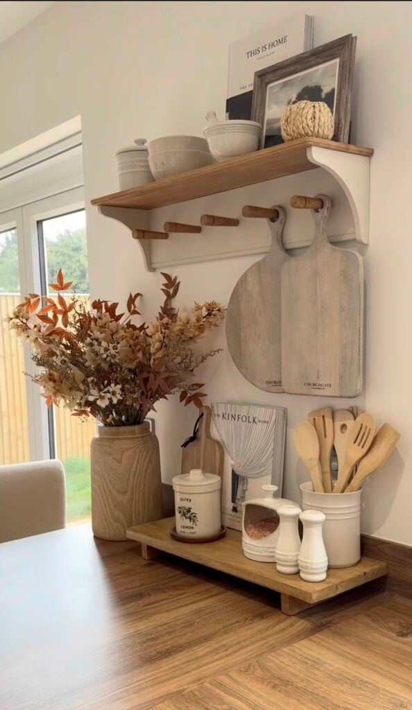 Neutral fall side table with ceramic pumpkin, candle, and cozy layered accents.