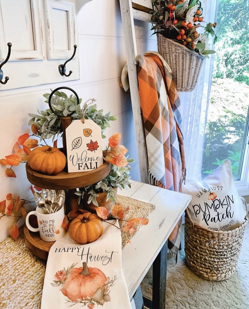 Fall tiered tray on table with blanket ladder in the background with plaid blanket in fall colors