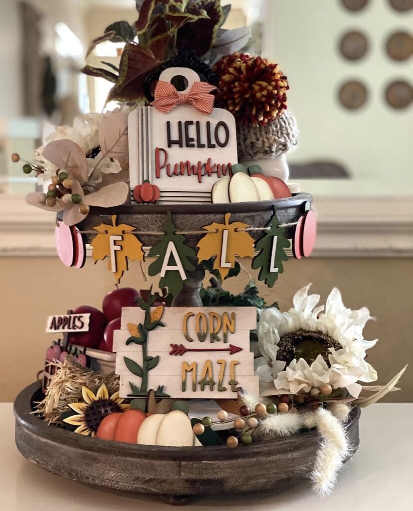 Two tiered tray decorations with deep colors of green, mustard yellow and burgundy for a fall hay ride theme