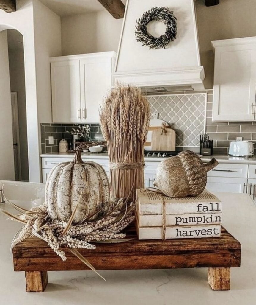 square wooden tray with wheat, books and neutral pumpkins