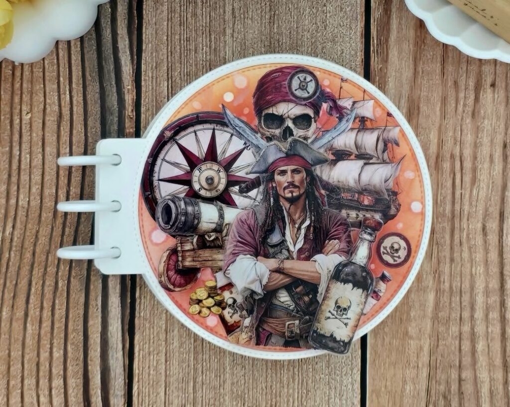 Round pirate mini album cover featuring a captain illustration, compass details, and vintage nautical embellishments.
