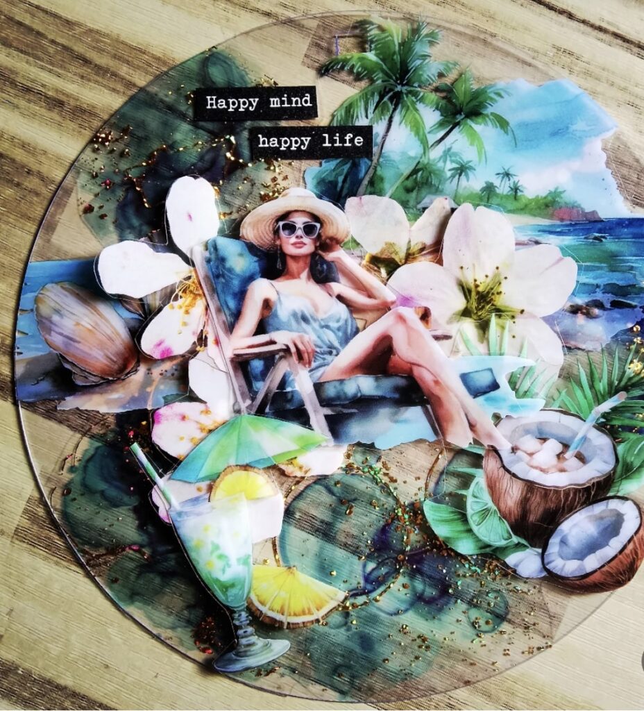 Tropical beach collage on a clear disc with a woman lounging, ocean and palm trees, cocktails, and the phrase “Happy mind happy life.”