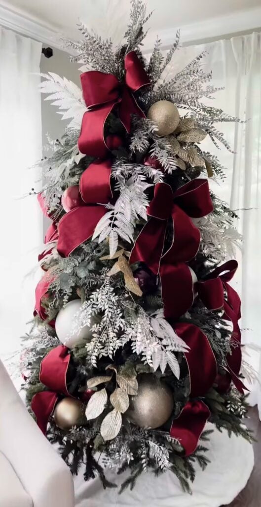 burgundy ribbon and gold leaf Christmas tree with luxe winter forest vibe