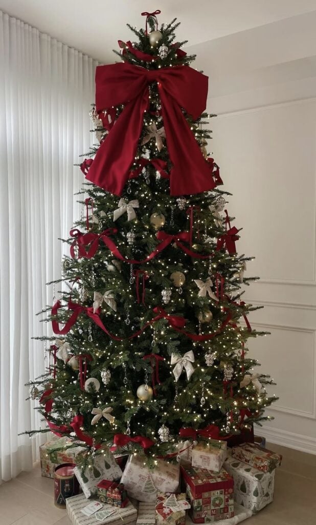 classic holiday palette tree with giant red bow, draped red ribbon, crystal drop ornaments, gold and ivory baubles, presents underneath