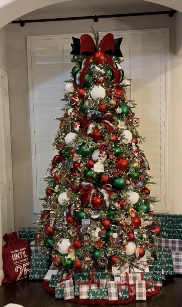 Classic glam Christmas tree in red and green with plaid bows, heirloom memory ornaments, and traditional trim.