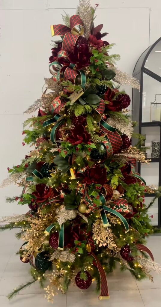 Classic-color glam Christmas tree in traditional red, green, and gold with layered ribbon, metallic baubles, and full coverage styling.