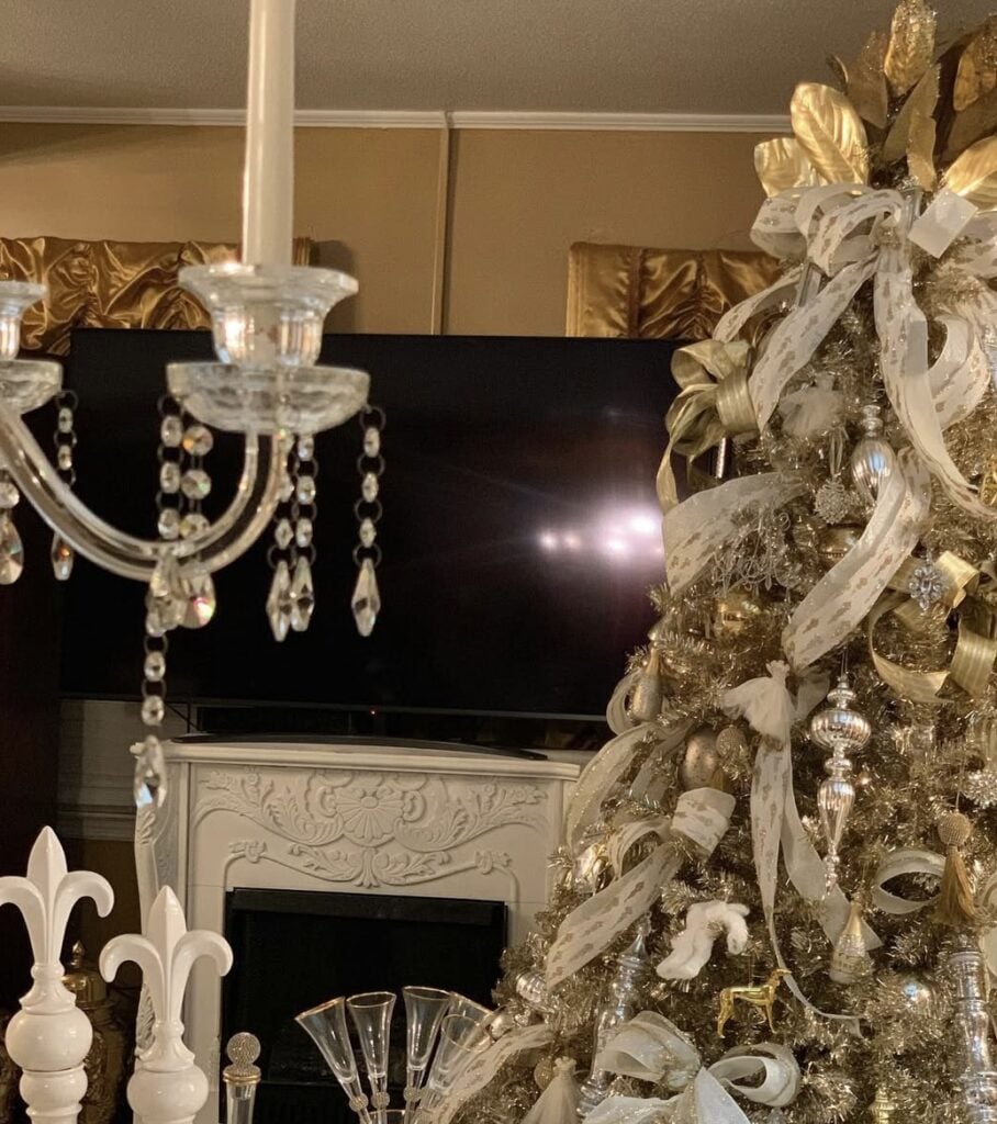 Vintage-inspired glam Christmas tree with crystal chandelier accents and gold ribbon.