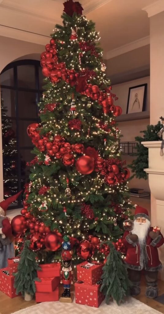 Classic red-garland glam Christmas tree with nutcracker accents and traditional ornaments.