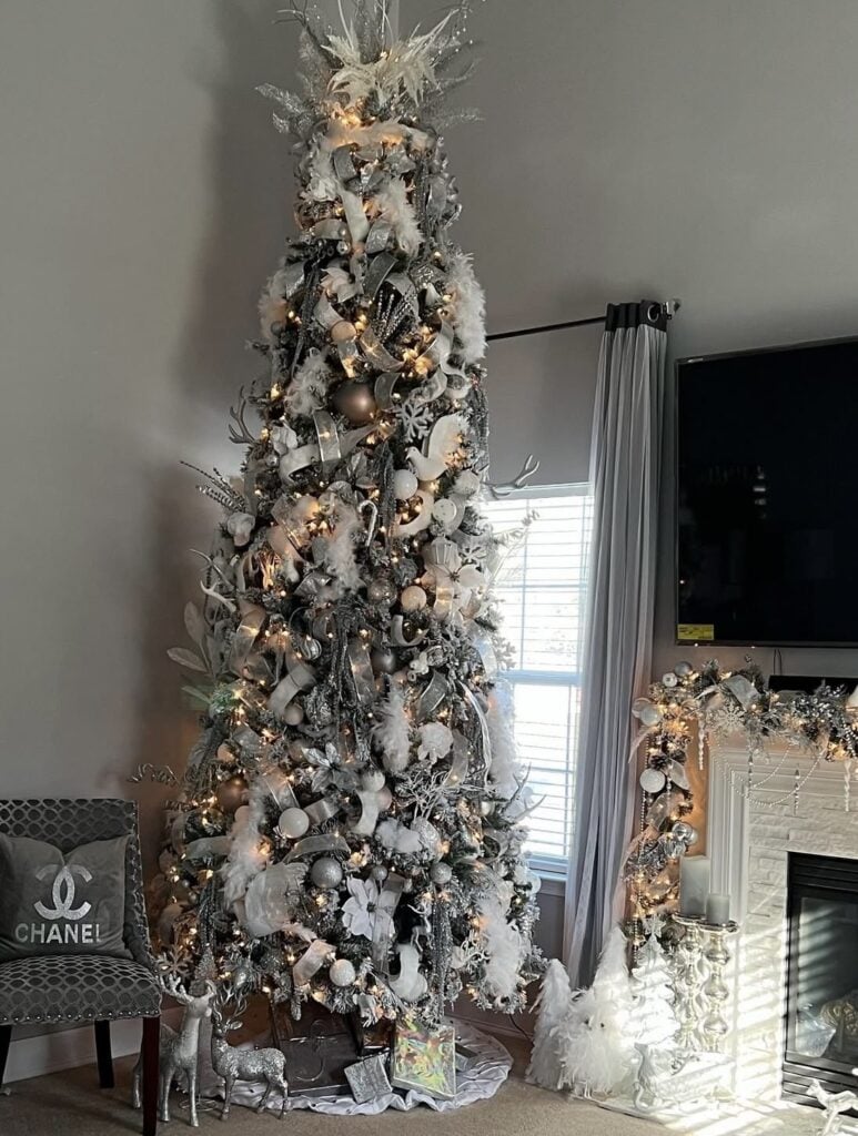 Silver-and-white winter-wonderland glam Christmas tree with feathered accents and frosted ornaments.