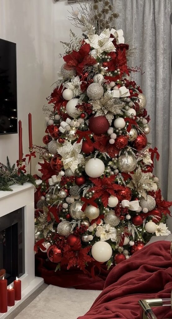 glamorous red and white Christmas tree with poinsettias, oversized ornaments, and sparkle bows