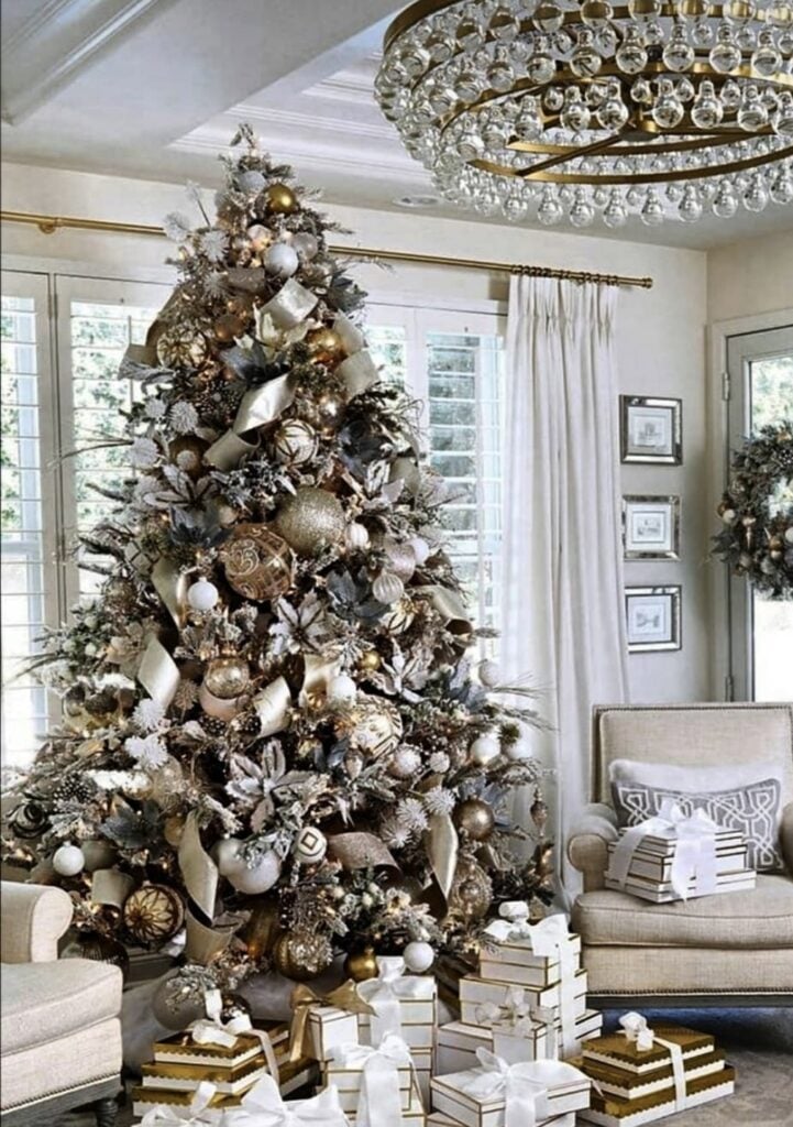 Luxury living room glam Christmas tree with layered gold and silver ribbon and metallic ornaments.