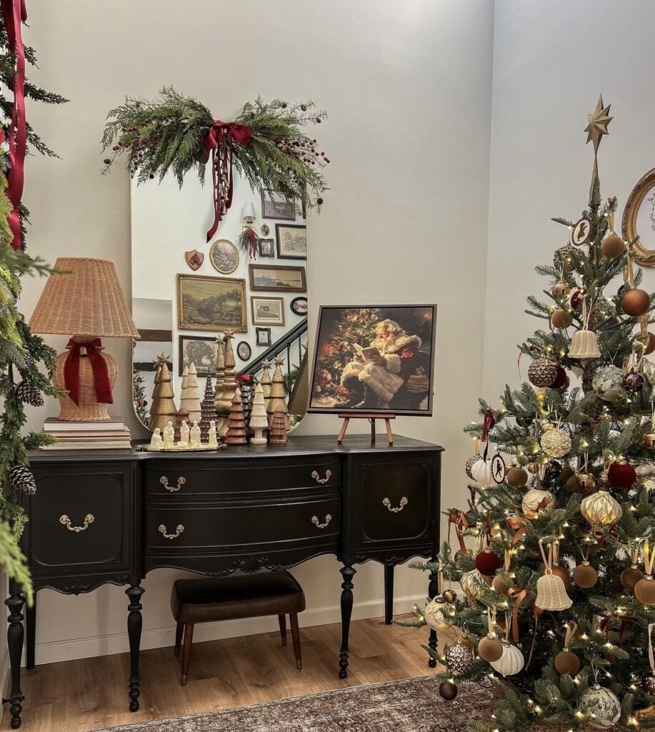 vintage gallery wall and Christmas tree vignette with Santa art and black sideboard