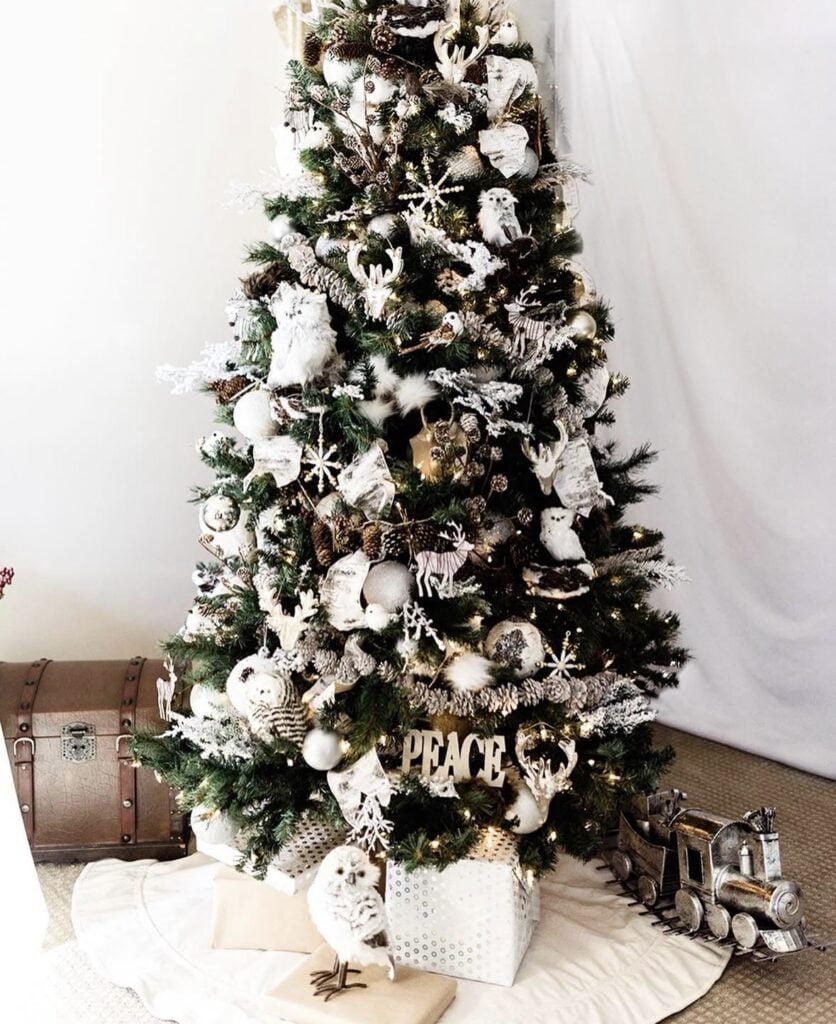 Woodland-themed Christmas tree with owl and reindeer ornaments and a pine cone garland