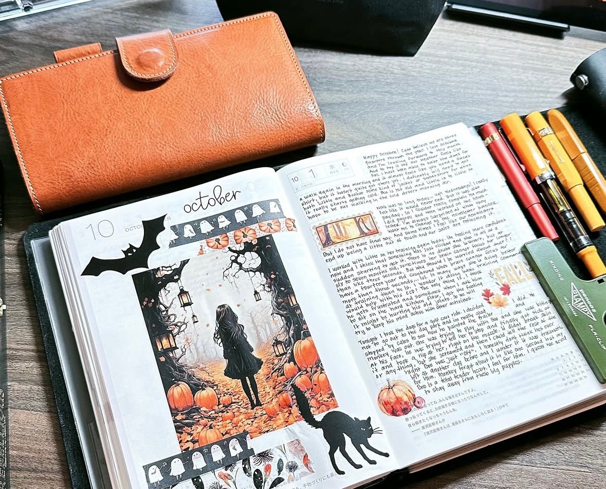 Bullet journal weekly spread with pumpkins, forest trees, and black cat accents