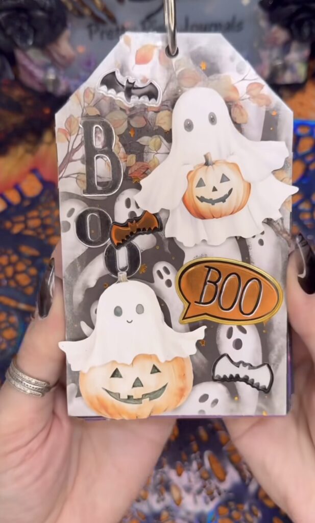 Decorative ghost tag with layered ephemera, eyelets, and ribbon—perfect for tuck spots.