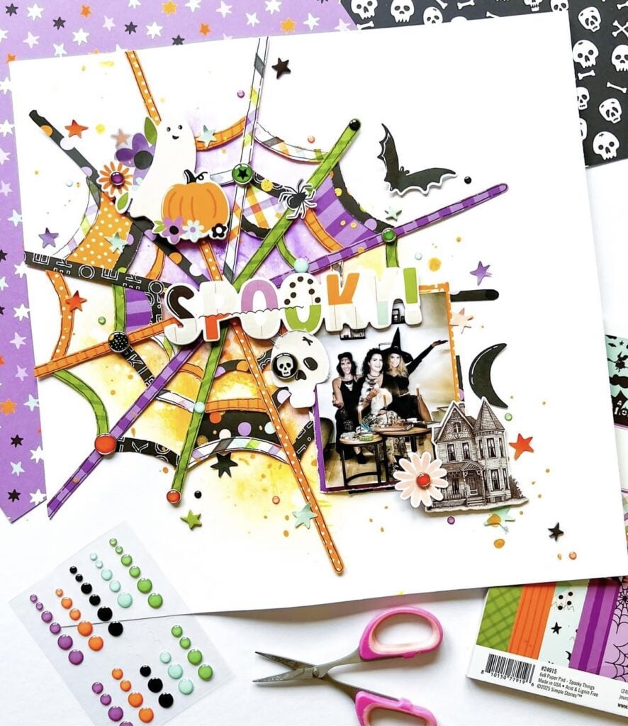 Colorful spiderweb scrapbook layout with ‘Spooky’ title in purple, orange, and green, plus ghost and bat icons around a photo