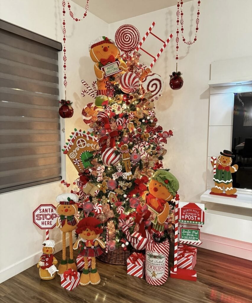Bright gingerbread candy land Christmas tree with red and green ornaments, lollipops, and playful candy cane details.